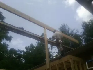 Carpenter setting a ridge beam over a new addition frame — Ice Dam Removal by Roofing Brothers in Vincentown