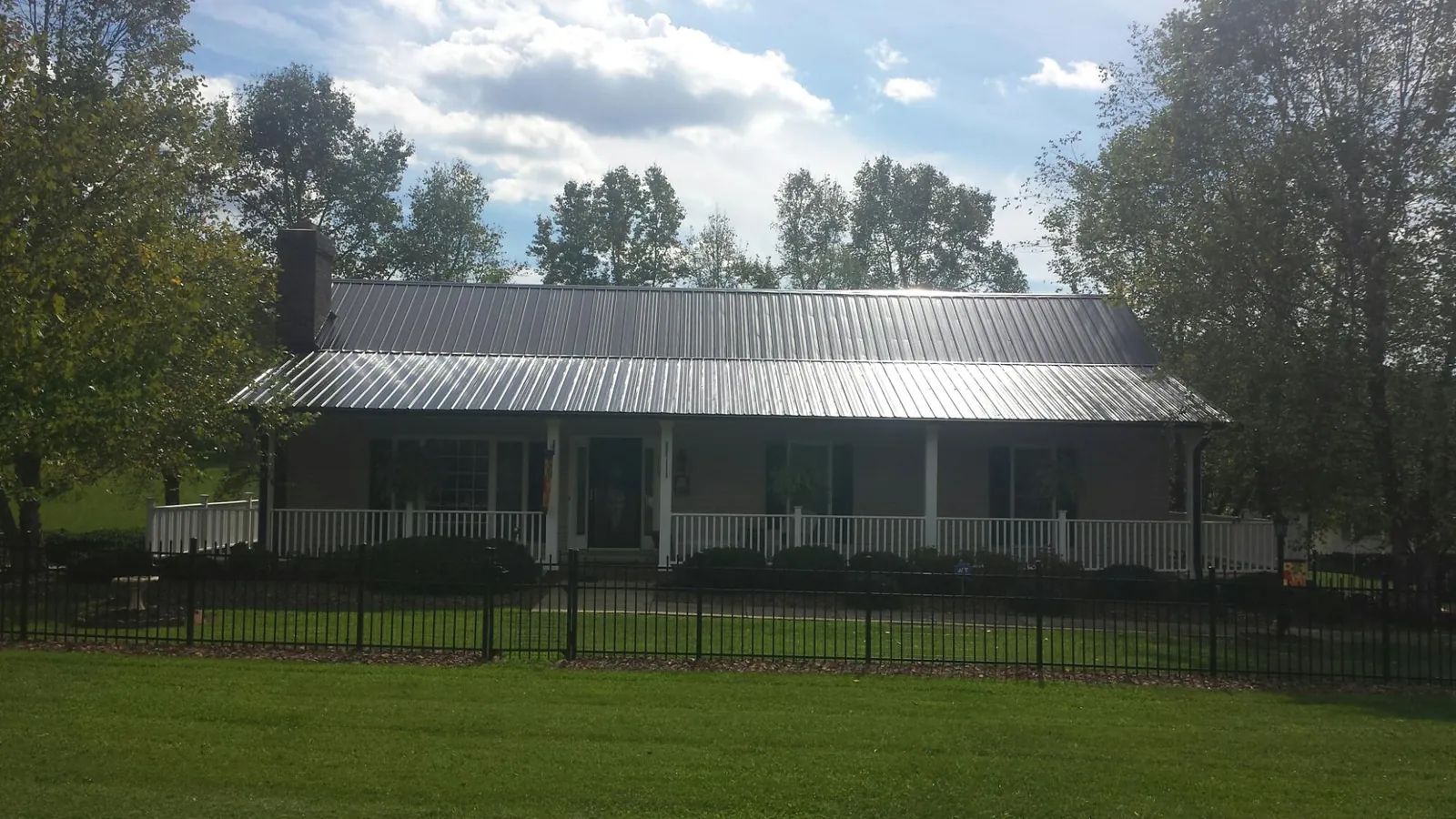 Gray metal roof on a brick ranch with a full width front porch — Gutter Guard Installation work by our crew in Vincentown