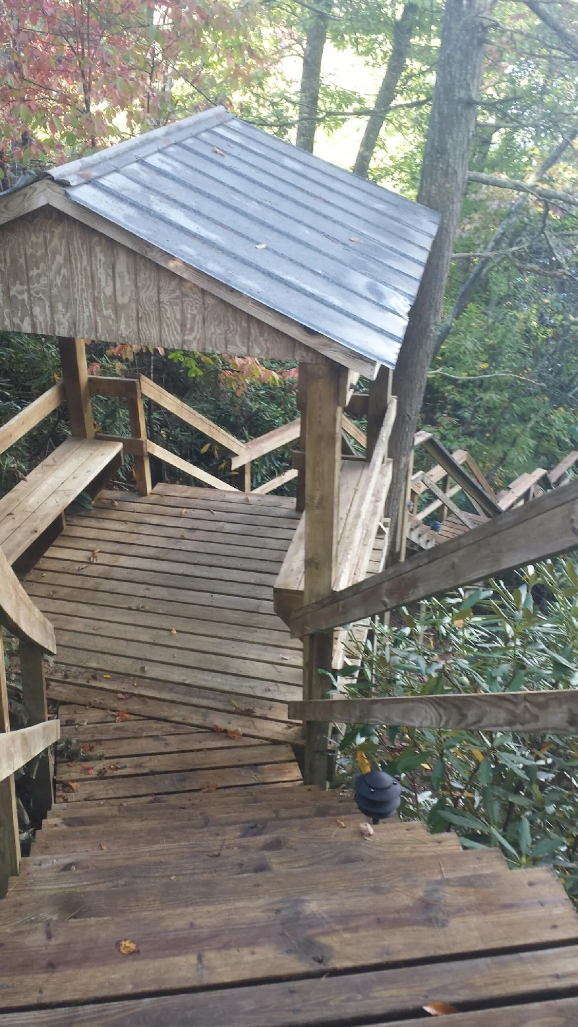 Metal roofed shelter over wooden steps on a wooded walkway — Skylight Repair & Installation work by our crew in Vincentown